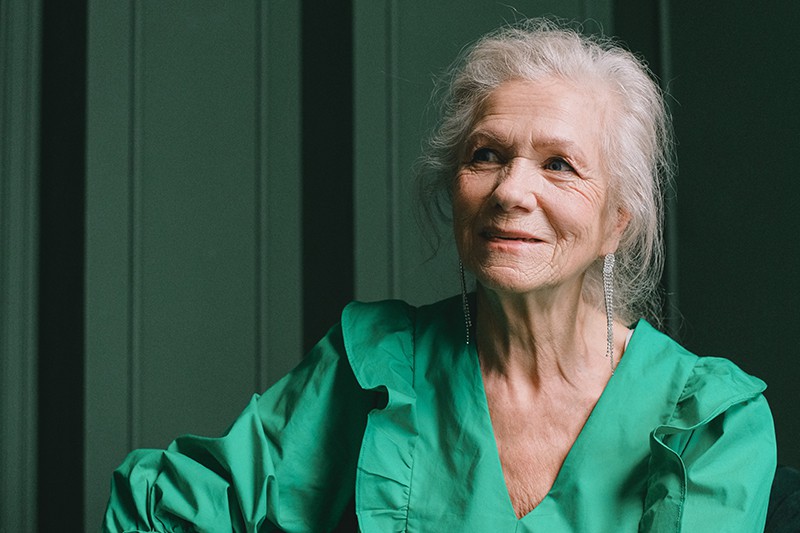 lange zilveren oorbellen bij een oudere vrouw staan ook prachtig